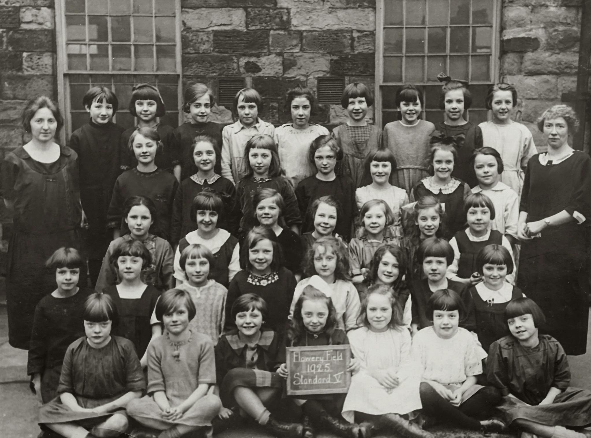 A historical vintage group photo of a school's class in 1925.